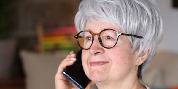 LGBT Elder Hotline - Older person using cellphone.